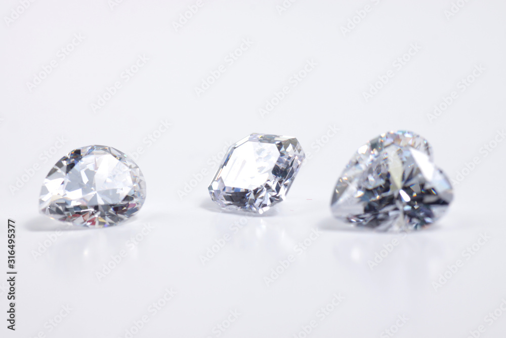 Macro shoots of a group of diamonds that has different shapes, heart, round, pear, asscher, oval, princess, isolated background Macro shoots of a group of diamonds that has different shapes, heart, round, pear, asscher, oval, princess, isolated background