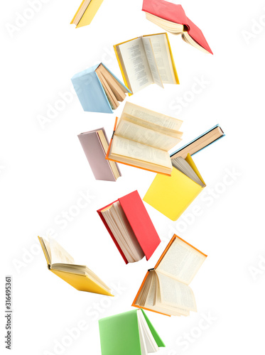 Colorful hardcover books flying on white background photo