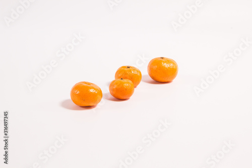 Tangerines on a white background one after another one in the foreground the rest are out of focus
