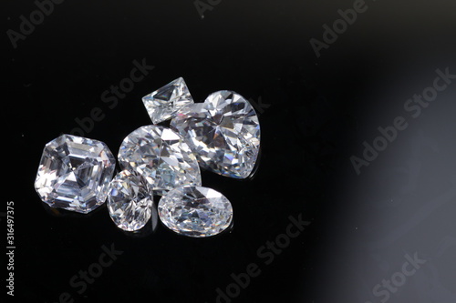 Macro shoots of a group of diamonds that has different shapes, heart, round, pear, asscher, oval, princess, isolated background