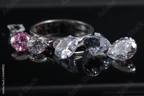 Macro shoots of a group of gold wedding ring and diamonds that has different shapes, heart, round, pear, asscher, oval, princess, isolated background