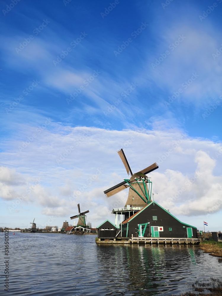 Zaanse Schans is the most beautiful village of netherlands people is coming from all over the world to admire the windmills that are now houses or museums the green fields and the tulips 