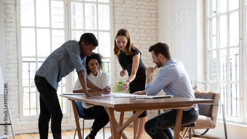 Successful motivated diverse employees team working with documents together