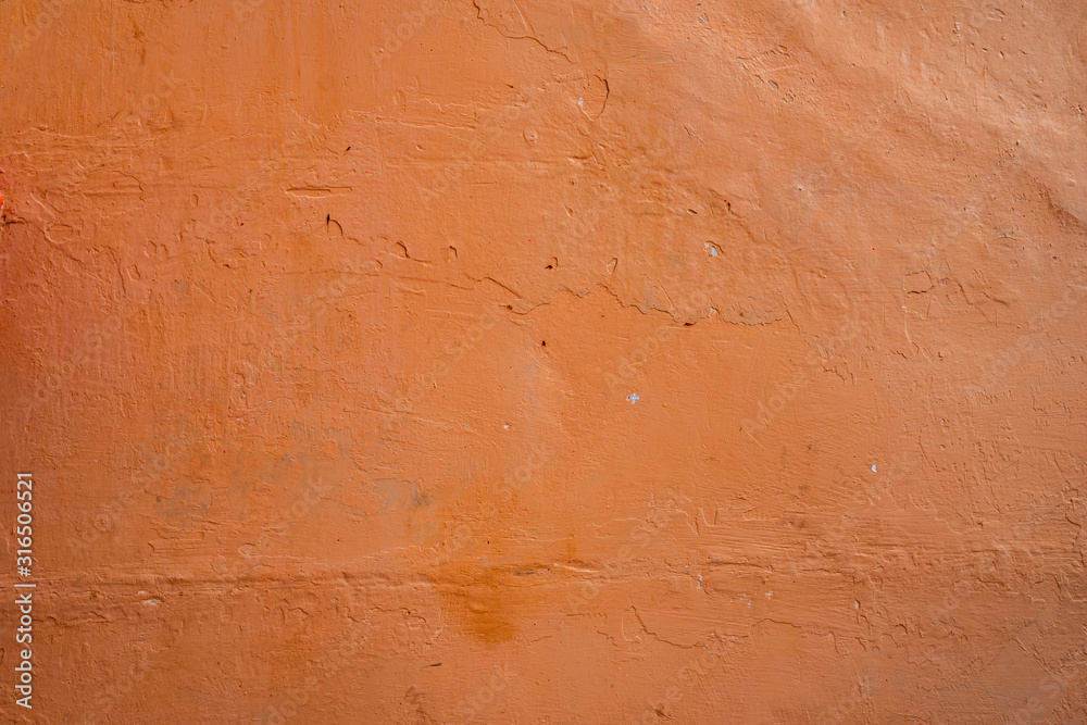 Old rough wall texture for background.  Wallpaper with vintage or retro colors.  Dark orange background.