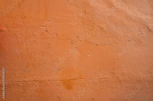 Old rough wall texture for background. Wallpaper with vintage or retro colors. Dark orange background.