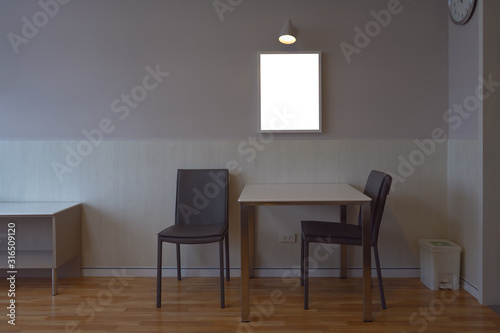 (Clipping path include) Blank frame template on the wall with lamp for photos and inscriptions. Cozy home interior with dinner table, chairs, clock and trash in the condominium. © fongleon356