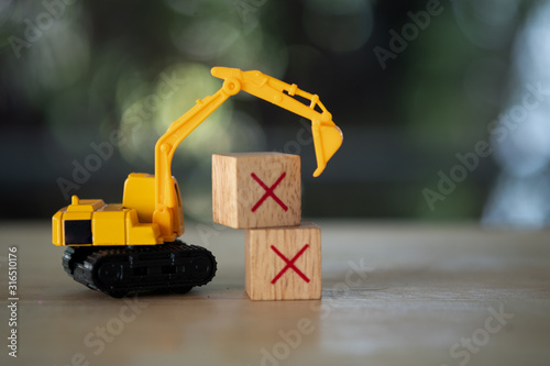 The yellow toy car Excavator and wooden cubes X. photo