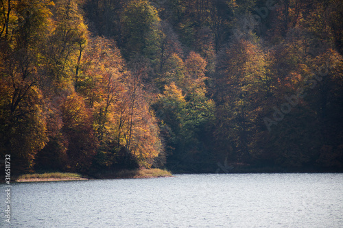 A calm evening landscape with lake and mountains. Amazing view of the Goy-Gol (Blue Lake) Lake among colorful fall forest at Ganja, Azerbaijan.