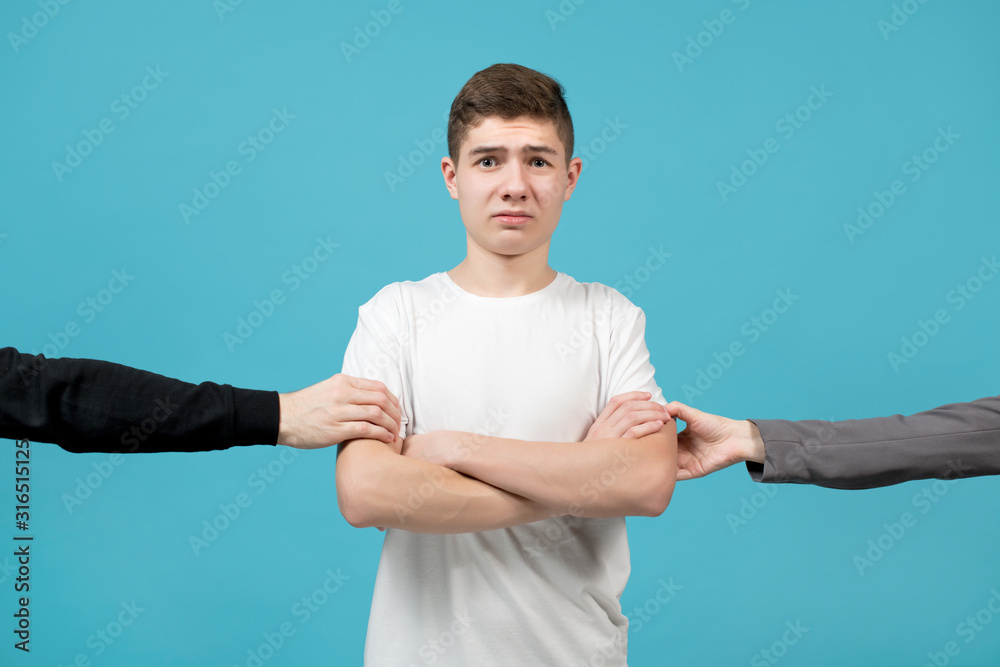 hands of people behind the scenes pulling somewhere a young guy in a white T-shirt hands of people behind the scenes pulling somewhere a young guy in a white T-shirt