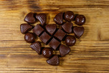 Heart shape made of different chocolate candies on wooden table. Top view. Valentine Day concept