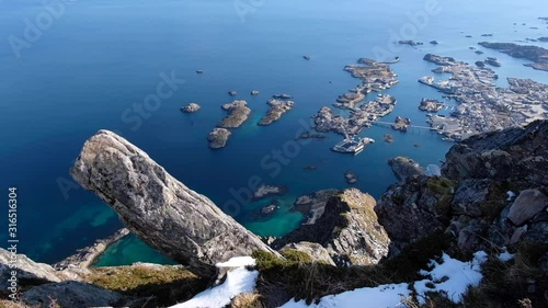 Camera tilts up to reveal horizon above Svolvaergeita. View of the blue ocean water. Norway. photo