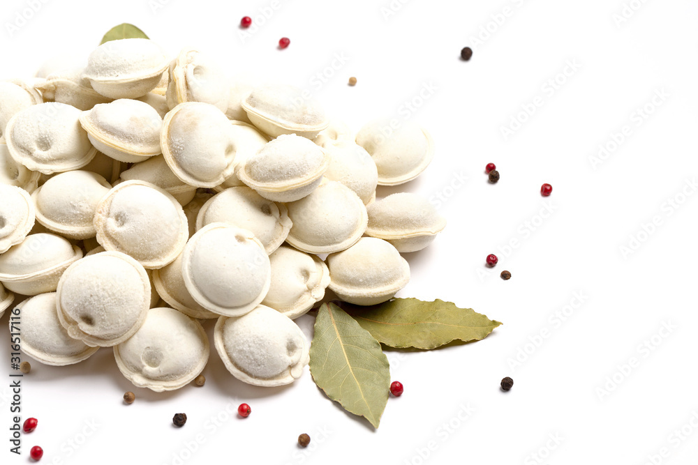 Dumplings with the bay leaves and of pepper. Russian pelmeni with peppercorns on white background. Frozen raw dumplings.