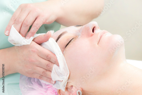 Procedure female cosmetic mask and chistak face in a beauty salon.