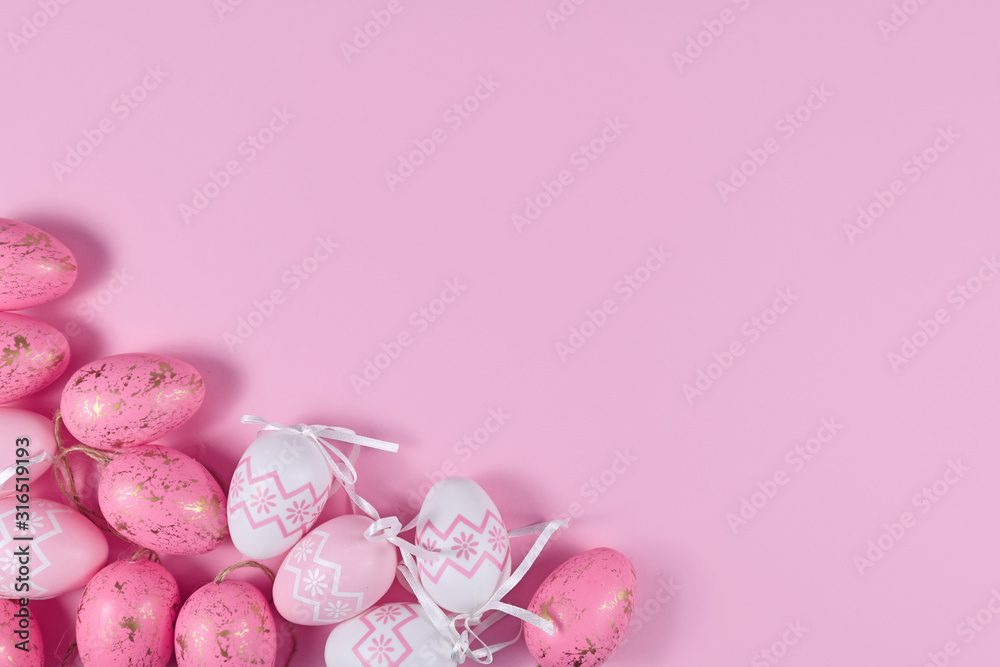 Easter flat lay with easter eggs in corner and empty copy space on pink background