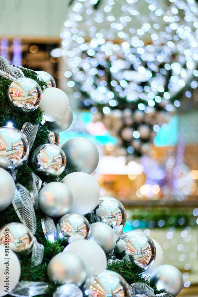 Christmas white balls on branches with a beautiful blurred background of lights.