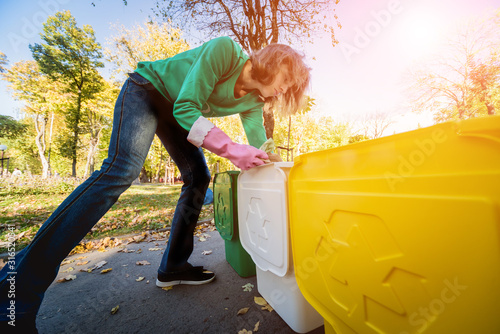 Volunteer girl sorts garbage in the street of the park. Concept of recycling. Zero waste concept. Nature