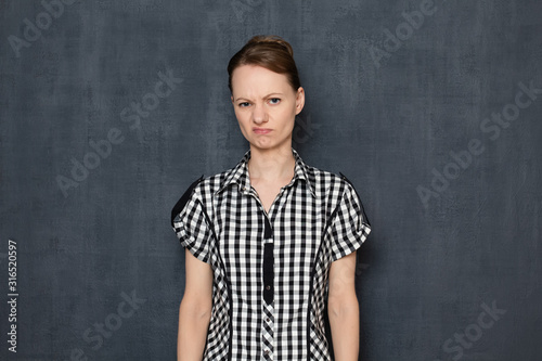 Portrait of annoyed dissatisfied young woman wearing checkered shirt © Andrei Korzhyts