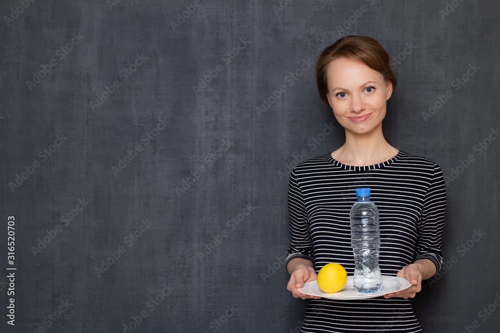 Portrait of happy girl holding lemon and bottle of water and smiling Portrait of happy girl holding lemon and bottle of water and smiling