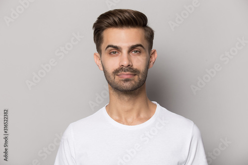 Millennial confident concentrated guy looking at camera portrait.