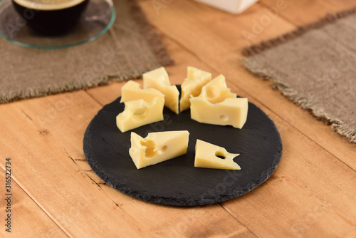 Cheese on a slate plate on the wooden table