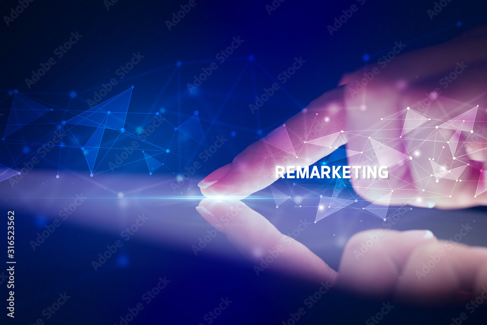 Finger touching tablet with REMARKETING inscription, business concept Finger touching tablet with REMARKETING inscription, business concept