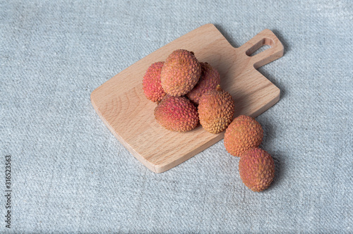 Fresh lychee fruit on a wooden background.