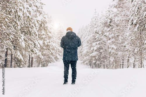 Photographer in winter frost covered forest