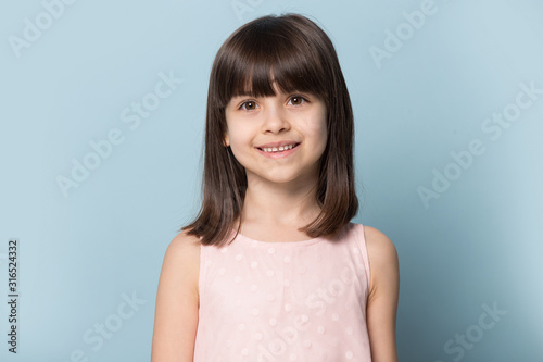 Little pretty smiling girl head shot studio portrait.