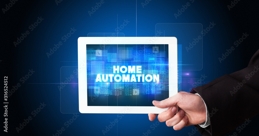 Young business person working on tablet and shows the inscription: HOME AUTOMATION Young business person working on tablet and shows the inscription: HOME AUTOMATION