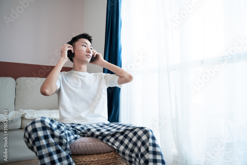 Asian Young Man Listening Music On Headphone  Indoors