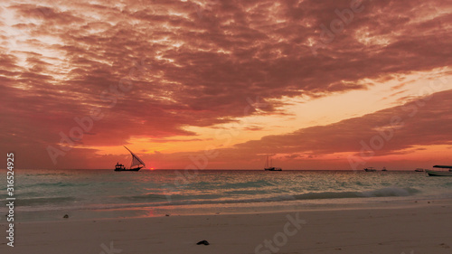 Fototapeta Naklejka Na Ścianę i Meble -  Sansibar sonnenuntergang im Afrika mit Boot im Hintergrund