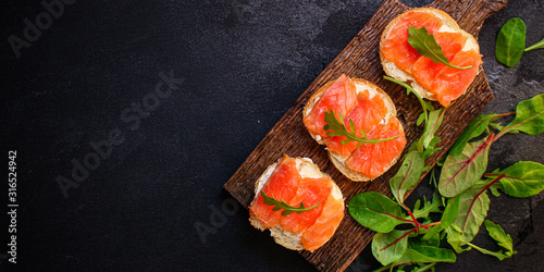 sandwich salmon smorrebrod (delicious snack seafood fish) menu concept. food background. top view. copy space