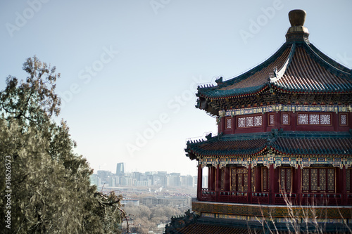 Traditional chinese pagoda in red blue and yellow  with a city as a background.