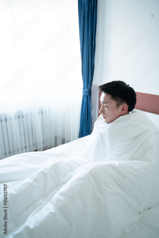 asian young man wrapped in plaid on bed asian young man wrapped in plaid on bed