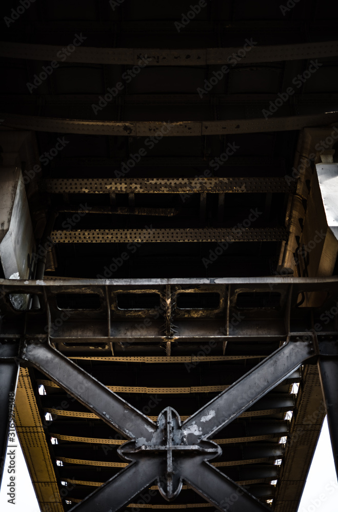 Dark and gloomy industrial atmosphere under the historical rail bridges in Manchester subway symmetry sun rays day summer blue sky Dark and gloomy industrial atmosphere under the historical rail bridges in Manchester subway symmetry sun rays day summer blue sky
