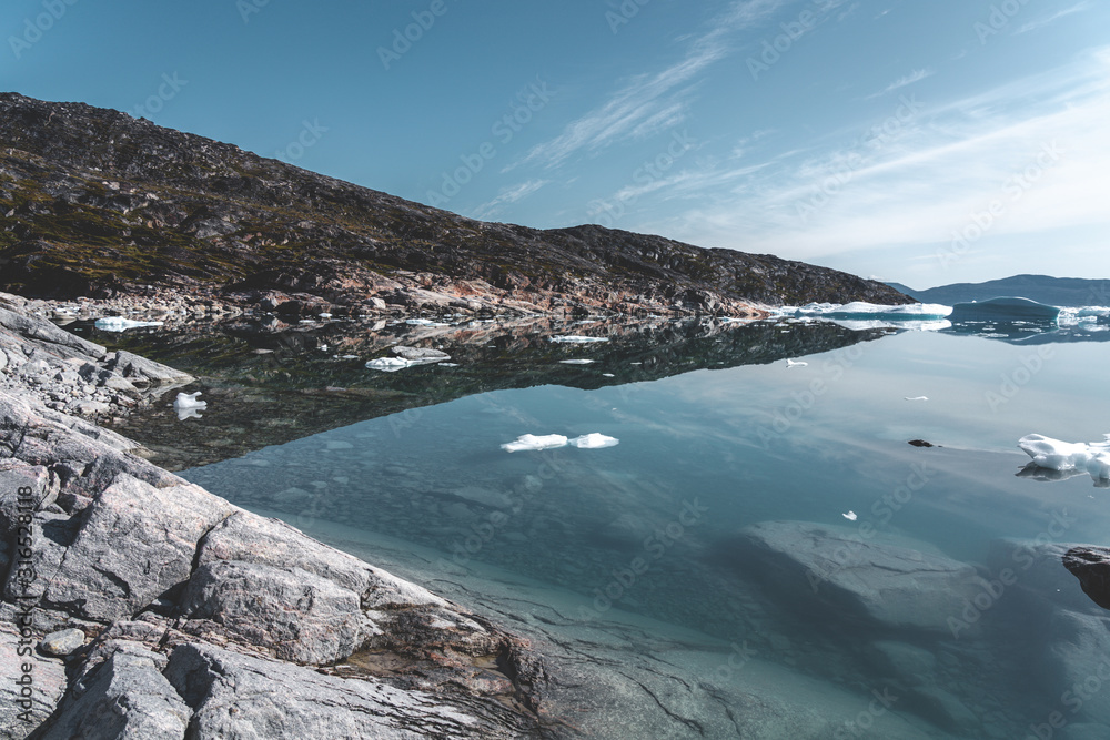 Beautifull landscape with floating icebergs in glacier lagoon and lake in Greenland. Ilulissat Icefjord Glacier. Iceberg and ice from glacier in arctic nature landscape.