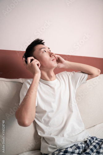 Asian Young Man Listening Music On Headphone, Indoors
