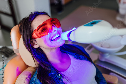 Teeth whitening for woman. Bleaching of the teeth at modern dentist clinic. photo