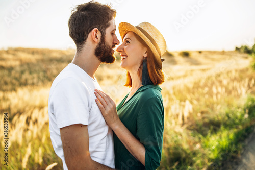 Happy young man and woman smiling and hugs outdoor at sunset. Concept of people, love and lifestyle