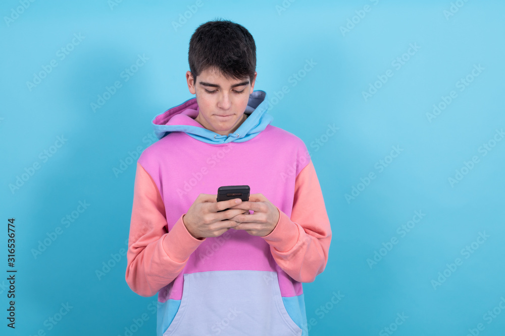 trendy teenage young man with mobile phone isolated on color background trendy teenage young man with mobile phone isolated on color background
