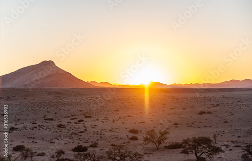 The rising sun is casting long shadows across the Dune Landscape of the Khomas Region in Central Western Namibia. © Goldilock Project