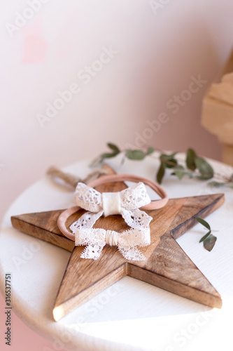 Beautiful fashion accessory for baby girls. Handmade accessories lace and stars on elastic band on white and brown background. Concept of children's clothing.