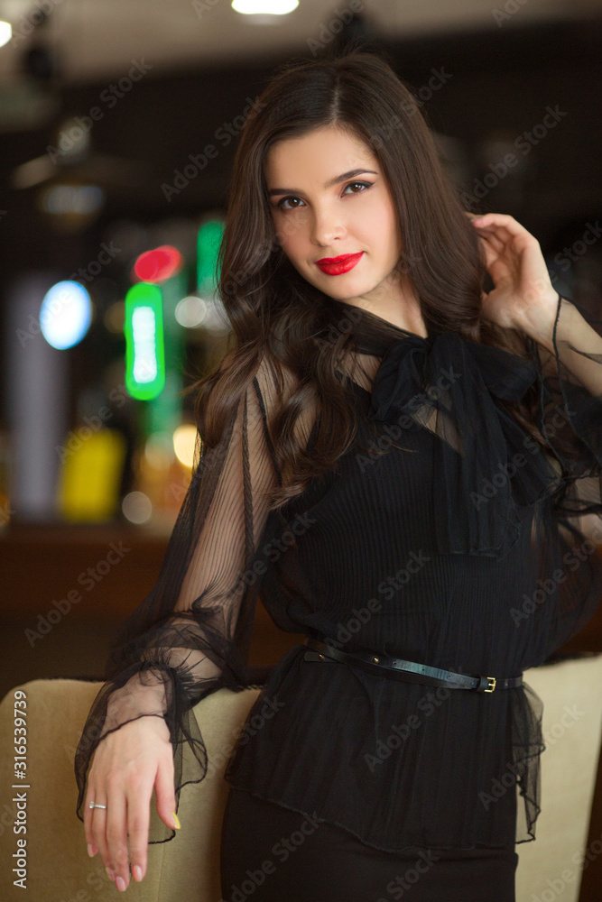 portrait of a beautiful young woman in a black dress indoors Stock ...
