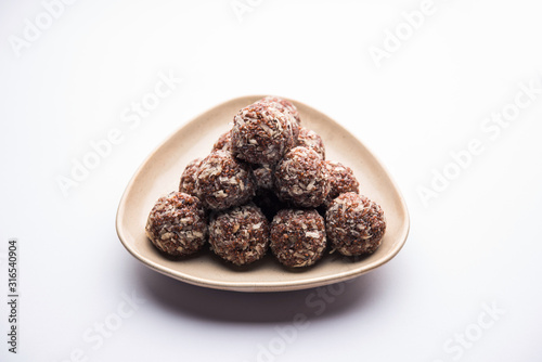 Aliv Laddu, Halim Ladoo or Garden cress Seed sweet Balls a very nutritious food in winters or for New Moms. popular food from India. served in a bowl or plate photo