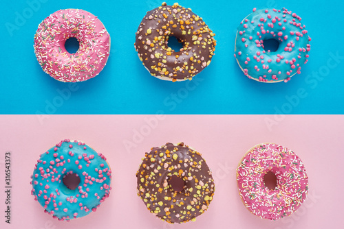 Donuts on a pastel pink and blue background. Minimalism creative food composition. Flat lay style