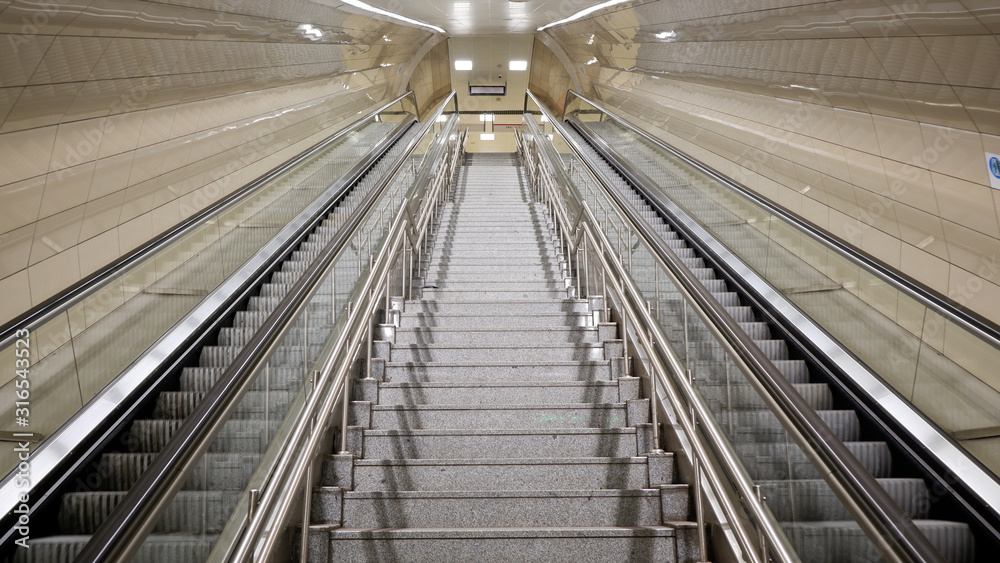 Stairs between escalators at empty metro station Stairs between escalators at empty metro station