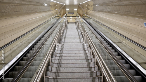 Fototapeta Naklejka Na Ścianę i Meble -  Stairs between escalators at empty metro station