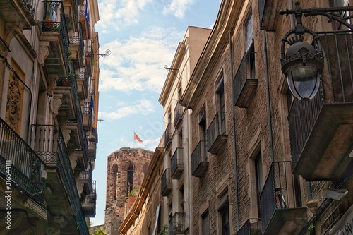Fototapeta Naklejka Na Ścianę i Meble -  Small streets at Gothic Quarter of Barcelona, Spain. Blue sky with clouds