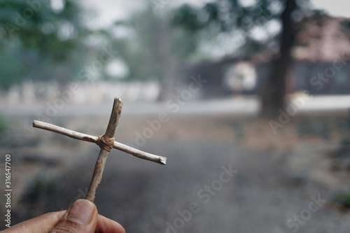 Hand holding a cross. Jesus Christ. Symbol of The belief christ religion at tomb
