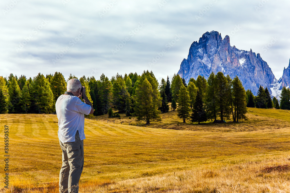  Gray-haired tourist photographs landscape